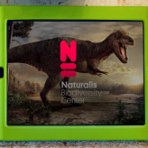 Dinosaurus afbeelding met Naturalis logo op een tablet met groene hoes.