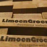 Closeup van gestapelde Jenga blokken met LimoenGroen logo